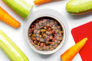 Dry dogfood with carrot and zucchini on table background top view photo