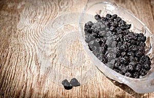 Dry, dried chokeberry - aronia in bowl on rustic table