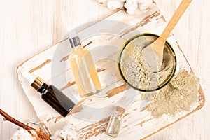 Dry facial clay powder mask in a jar and beauty essence bottles