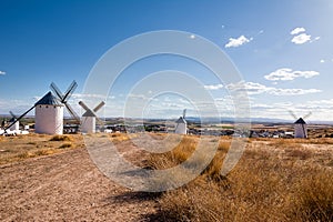 Dry field with ancient windmills and below the village of Campo de Criptana, Spain