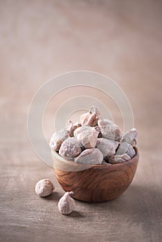 Dry figs in wooden bowl on wood textured background. Copy space. Superfood, vegan, vegetarian food concept. Macro of fig texture,