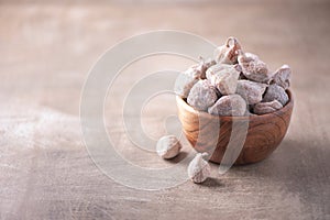 Dry figs in wooden bowl on wood textured background. Copy space. Superfood, vegan, vegetarian food concept. Macro of fig texture,