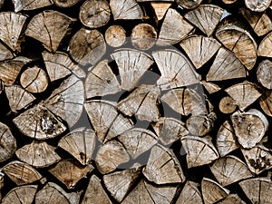 Dry firewood stacked in a pile, chopped wood for winter heating fuel of the fireplace.