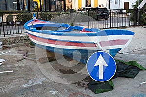 Dry fishing boat with a road sign