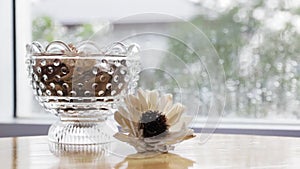 Dry flower on table with a glass of dry floral and raining background