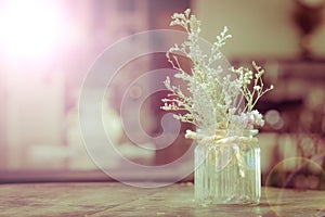 dry flowers in glass vase with rope on blurred background, copyspace. Vintage retro style. Len flare.