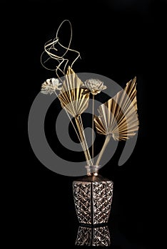 Dry flowers on a modern metal vase creating a beautiful abstract still-life composition