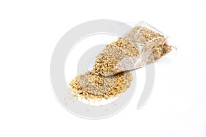 Dry food Daphnia for aquarium fish poured out of a plastic bag on a white background