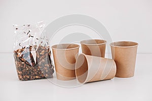 Dry fruit tea in a transparent plastic bag with disposable paper cups on a white background. Copy, empty space for text