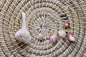 Dry garlic bulb with garlic cloves on woven basket background