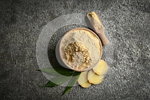 Dry ginger powder, fresh root and leaves on grey table, flat lay