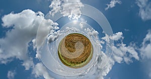 dry grass little planet loop transformation with curvature of space among fields in sunny day and beautiful clouds