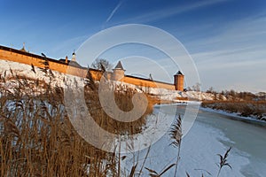 Dry grass in the winter on the background of frozen river and the castle