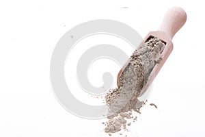 Dry green clay mask for face and body in a wooden spoon. Isolated on a white