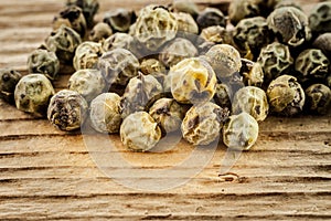 Dry green peppercorn on wooden background