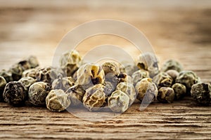 Dry green peppercorn on wooden background