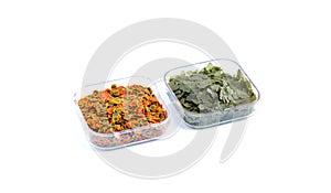 Dry green and red compound fish feed flakes in a transparent boxs on White background. Side view