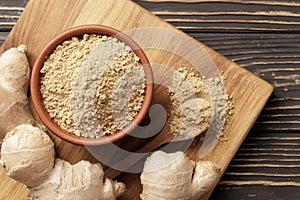 Dry and ground ginger on a wooden background. Dry ginger in a bowl. Ginger in a spoon.