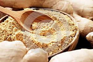 Dry and ground ginger on a wooden background. Dry ginger in a bowl. Ginger in a spoon.