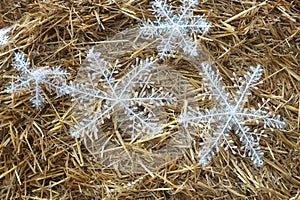 Rolled straw decorated with white snow crystals at rural animal farm as a christmas background