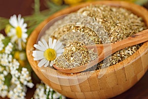 Dry herbal tea in wooden bowl