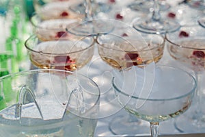 Dry ice cubes in glass cup close-up near pyramid of champagne. Dry ice for smoke effect when waiter puts ice into