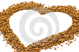 Dry instant coffee granules in the shape of a heart - brown texture