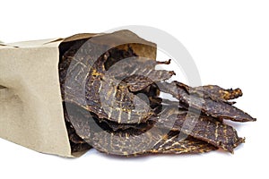 Dry jerky jerky for beer. Beef Jerky pieces in a paper bag on white background, isolated