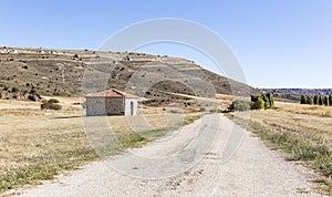 Dry landscape, a country road and a barn in Villaciervos, Soria, Spain
