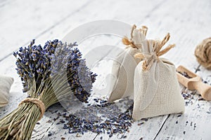 Dry lavender flower bouquets and aromatic sachets on white table