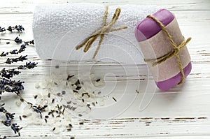 dry lavender flowers with soap, towel and sea salt on vintage wooden table. spa treatments