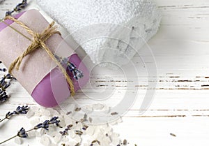dry lavender flowers with soap, towel and sea salt on vintage wooden table. spa treatments