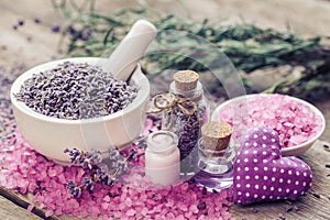 Dry lavender in mortar, sea salt, cream, essential oil and heart