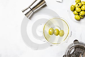 Dry martini cocktail with olives, gray background, top view