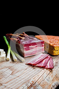 Dry meat and sausages with vegetables and cheese on a wooden table