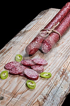 Dry meat and sausages with vegetables and cheese on a wooden table