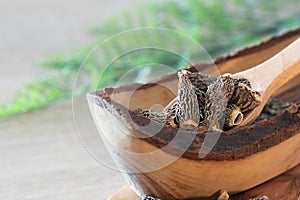 Dry Morel Mushrooms on Wooden Platter. Close-up of textured morel mushrooms, artfully arranged on a rustic wooden platter,