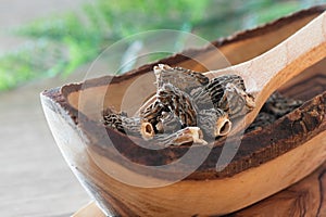 Dry Morel Mushrooms on Wooden Platter. Close-up of textured morel mushrooms, artfully arranged on a rustic wooden platter,