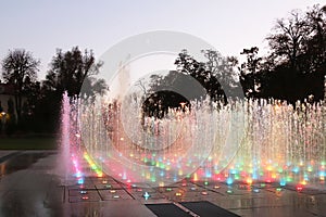 Dry musical fountain with a multi-colored pendant in the evening. Organization of recreation in the urban landscape. Park area