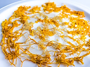 Dry orange zest on a white plate. Dry citrus zest, grated orange peel