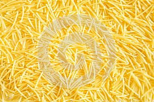 Dry pasta close-up. Culinary background, texture, pattern of yellow vermicelli. Copy space
