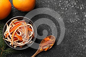 Dry peels, oranges and fir branch on gray textured table, flat lay. Space for text