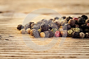 Dry peppercorn mix on wooden background