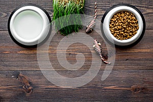 Dry pet - cat food in bowl on wooden background top view mock up