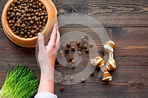 Dry pet - dog food in bowl on wooden background top view mock up