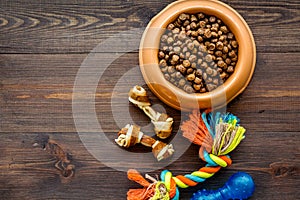 Dry pet - dog food in bowl on wooden background top view mock up