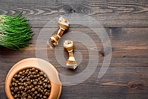 Dry pet - dog food in bowl on wooden background top view mock up