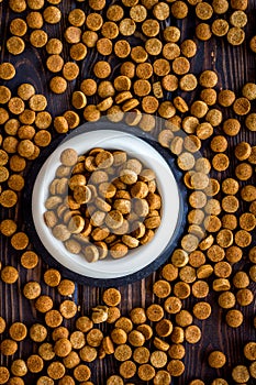Dry pet food on wooden background top view pattern