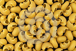 Pipe rigate pasta pattern on black background, top view, flat lay texture