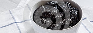 Dry prunes in a bowl, side view. Close-up